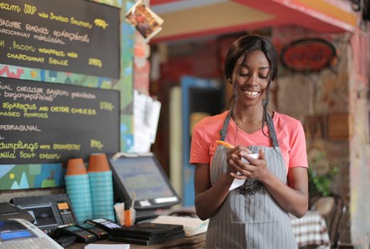 عشق در کسب و کار؛ زنی که با لبخند در حال گرفتن سفارش مشتری است