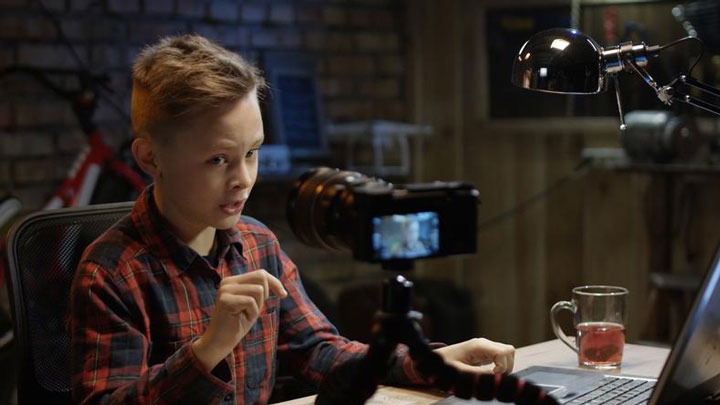 پسر نوجوانی در حال صحبت جلوی دوربین و یوتیوبری